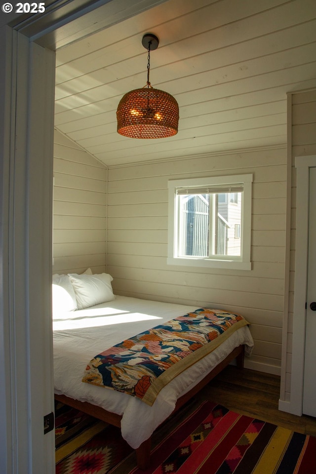 bedroom with vaulted ceiling and wood finished floors