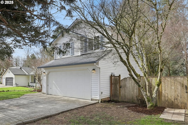 garage with driveway and fence