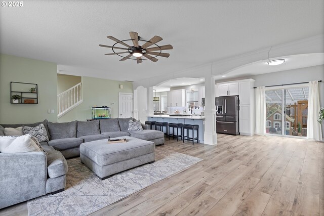 16436 Visionary Ct, Oregon City, OR 97045 - living room with ceiling fan, light wood-style floors, stairs, and arched walkways