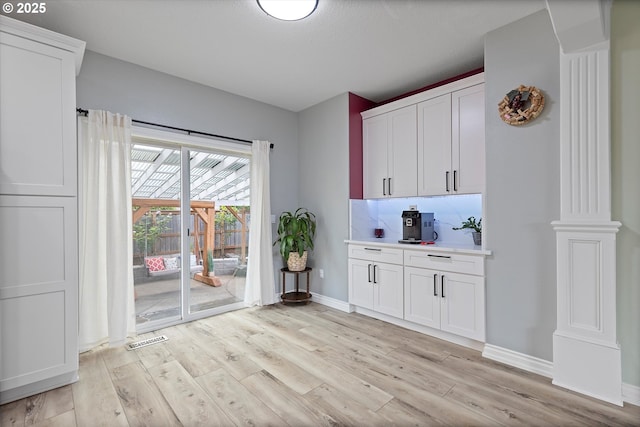 16436 Visionary Ct, Oregon City, OR 97045 - bar featuring light wood-style flooring, baseboards, decorative columns, and backsplash