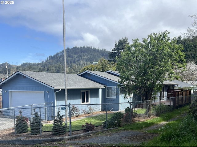 29519 Crook St, Gold Beach, OR 97444 - ranch-style house featuring a mountain view, a shingled roof, a garage, and a fenced front yard