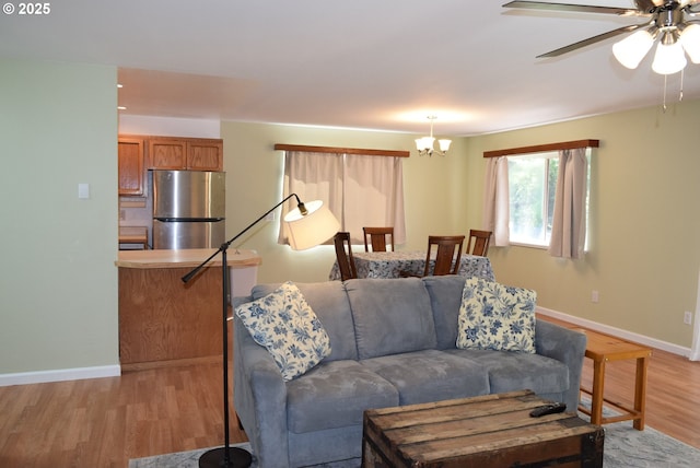 29519 Crook St, Gold Beach, OR 97444 - living room featuring light wood-type flooring, baseboards, and ceiling fan with notable chandelier