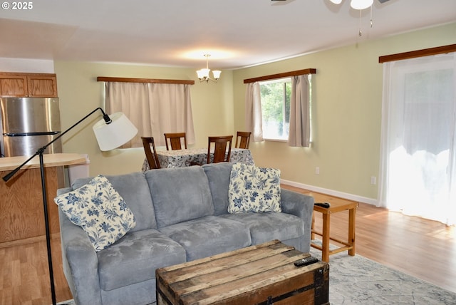 29519 Crook St, Gold Beach, OR 97444 - living area with ceiling fan with notable chandelier, light wood finished floors, and baseboards