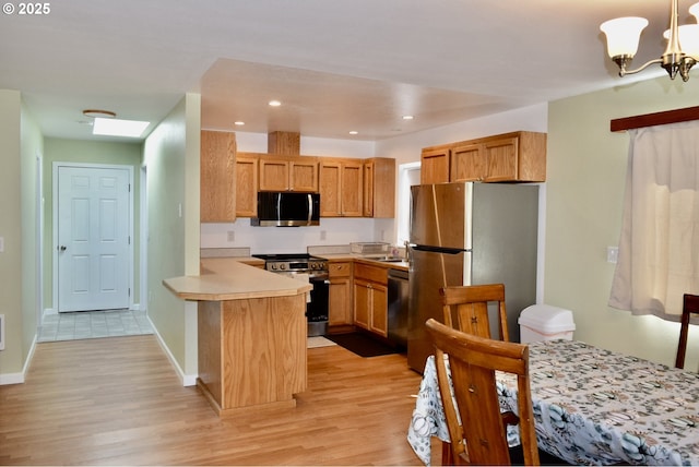 29519 Crook St, Gold Beach, OR 97444 - kitchen with an inviting chandelier, a peninsula, light countertops, light wood-style floors, and appliances with stainless steel finishes