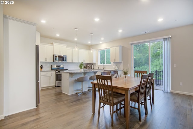 dining area with baseboards, recessed lighting, and wood finished floors