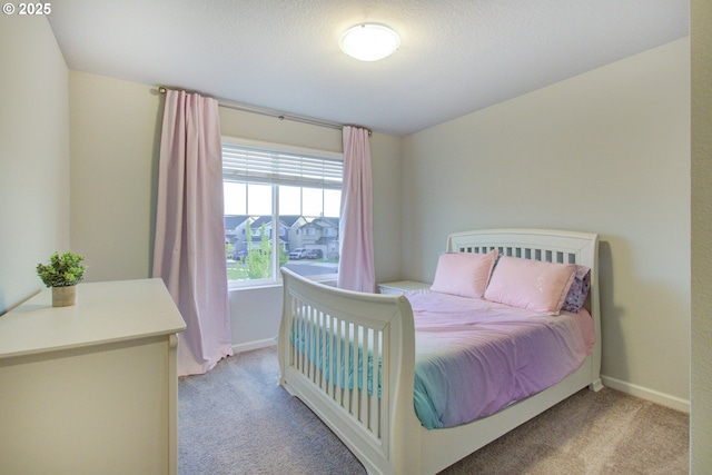bedroom with baseboards and light carpet