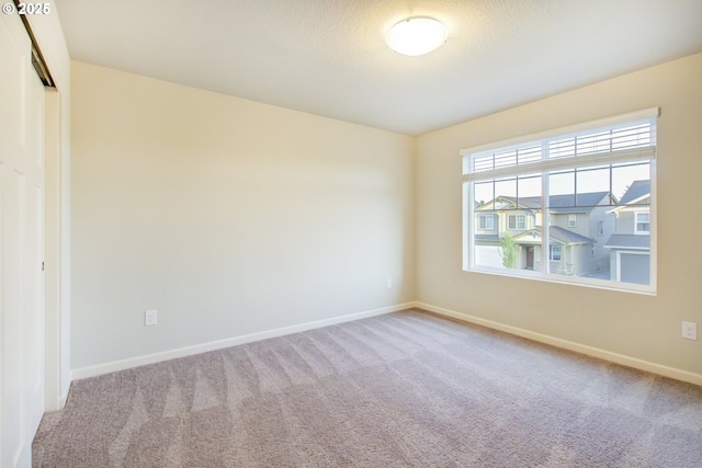 spare room with carpet flooring and baseboards