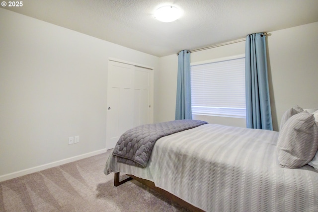 bedroom with carpet flooring, baseboards, and a closet