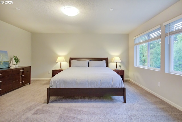 bedroom with baseboards and light carpet
