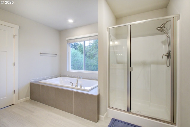 bathroom featuring baseboards, a stall shower, recessed lighting, and a garden tub
