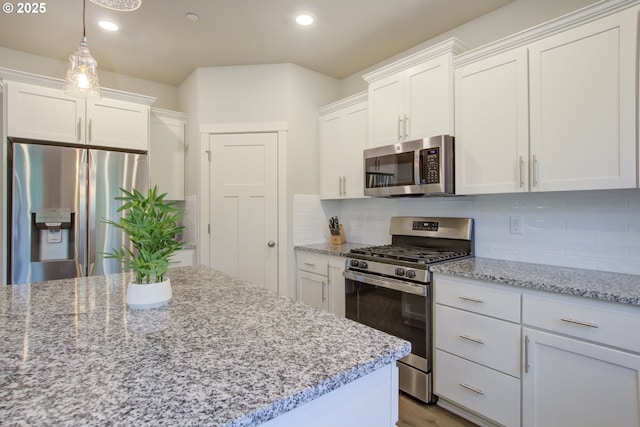 kitchen featuring light stone counters, decorative backsplash, white cabinets, and stainless steel appliances