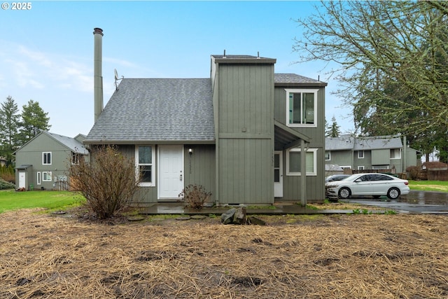 view of front of property featuring a shingled roof and a chimney