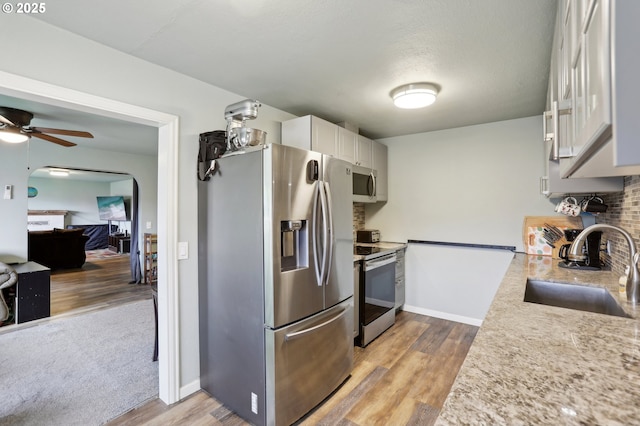 324 N 18th St, Saint Helens, OR 97051 - kitchen with appliances with stainless steel finishes, a sink, light wood-style floors, a ceiling fan, and white cabinetry