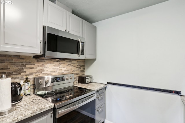 324 N 18th St, Saint Helens, OR 97051 - kitchen with stainless steel appliances, decorative backsplash, and white cabinetry