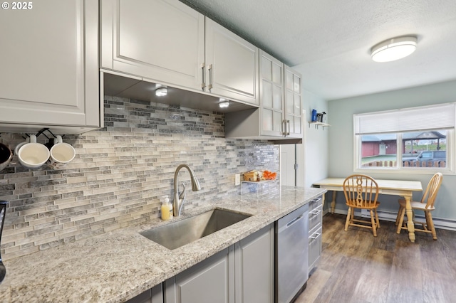 kitchen with sink, white cabinetry, dark hardwood / wood-style floors, dishwasher, and light stone countertops