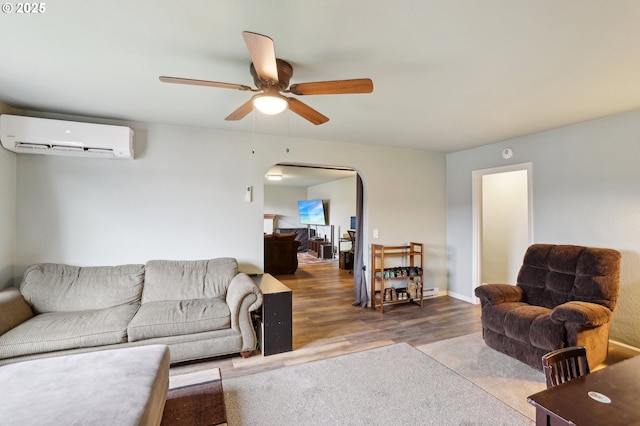 living room featuring hardwood / wood-style flooring, a wall mounted AC, and ceiling fan