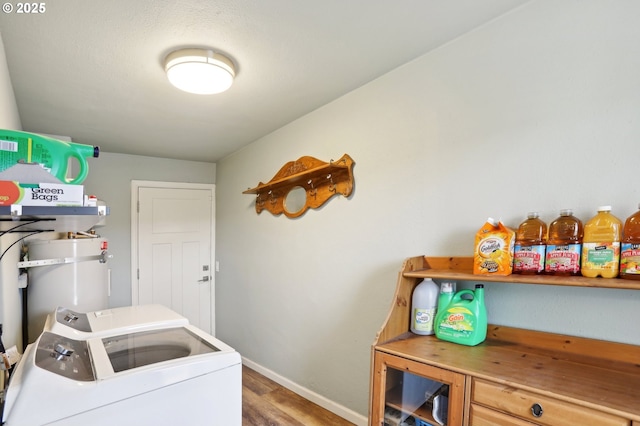 washroom featuring hardwood / wood-style flooring, washer and dryer, and secured water heater