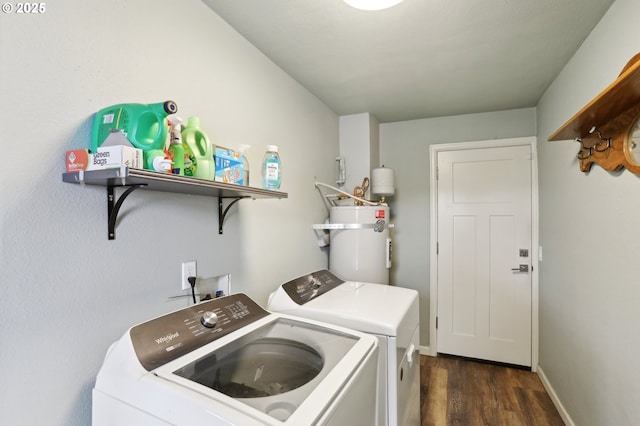 laundry area with dark hardwood / wood-style floors, washing machine and dryer, and water heater