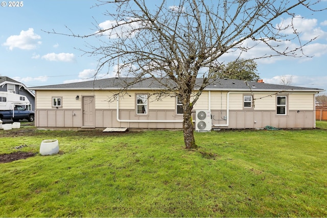 rear view of property featuring a yard and ac unit