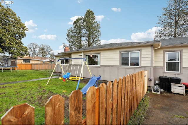 exterior space featuring a yard, a playground, and a trampoline