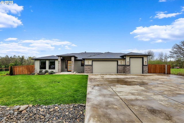 prairie-style house with a front yard, stone siding, fence, a garage, and concrete driveway