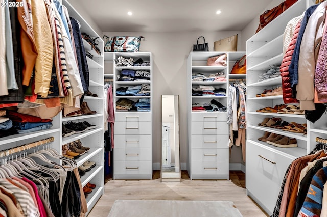 walk in closet with wood finished floors