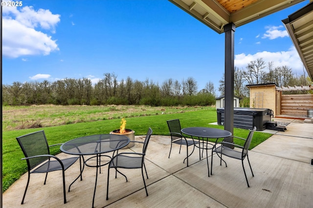 view of patio with a fire pit, outdoor dining area, and a hot tub