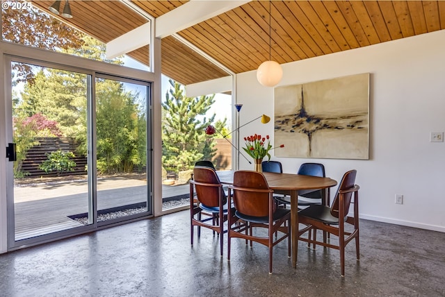 dining area with concrete floors, baseboards, lofted ceiling with beams, and wooden ceiling