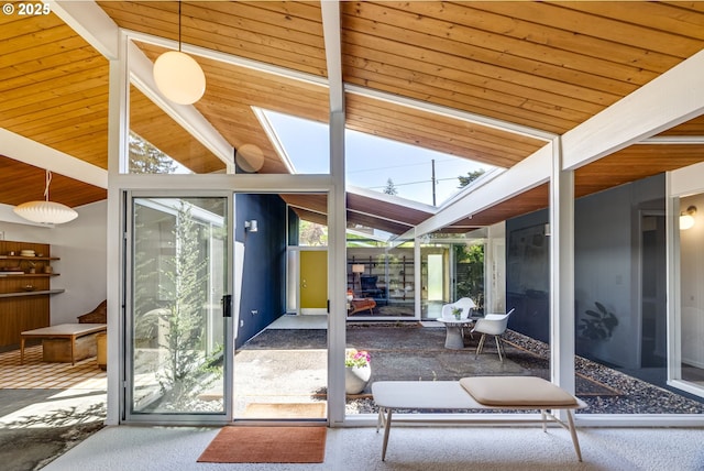 doorway featuring wood ceiling, carpet flooring, and lofted ceiling with skylight