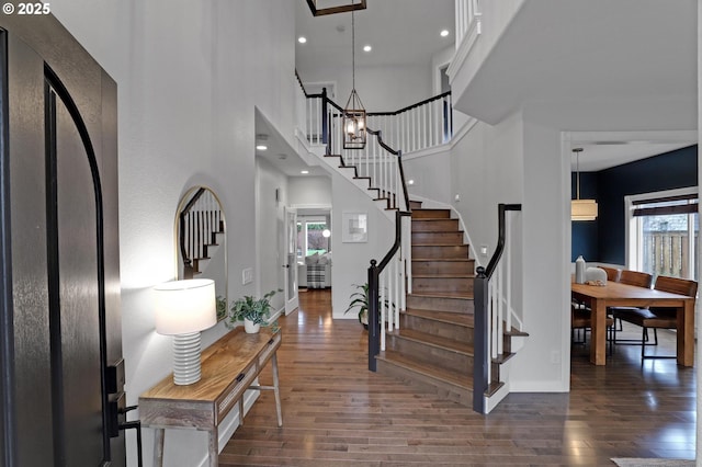 entrance foyer featuring a high ceiling, dark wood-type flooring, and a healthy amount of sunlight