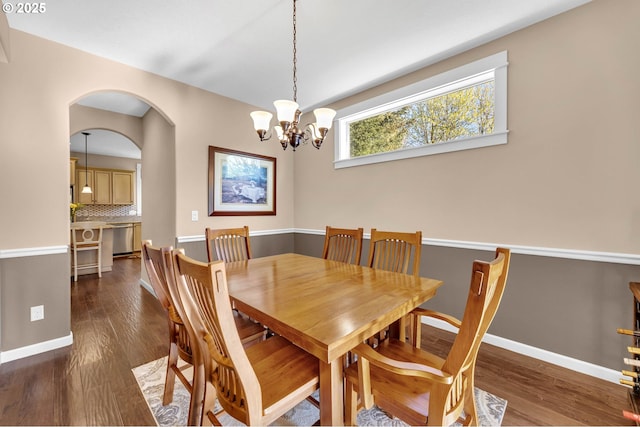 dining area with dark hardwood / wood-style flooring and a chandelier