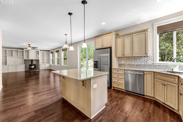 kitchen featuring sink, decorative light fixtures, a kitchen bar, decorative backsplash, and stainless steel appliances