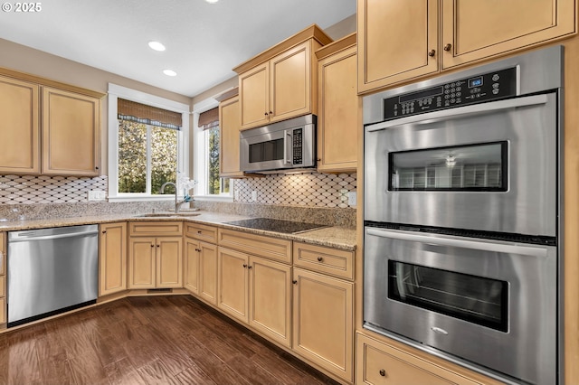 kitchen with light brown cabinets, dark hardwood / wood-style flooring, sink, light stone countertops, and stainless steel appliances