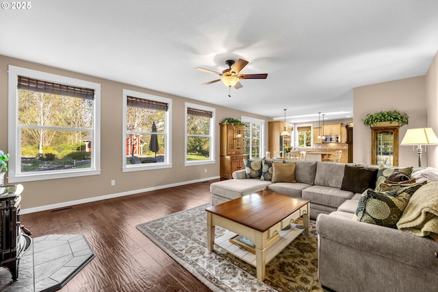 living room featuring ceiling fan, dark hardwood / wood-style floors, and plenty of natural light