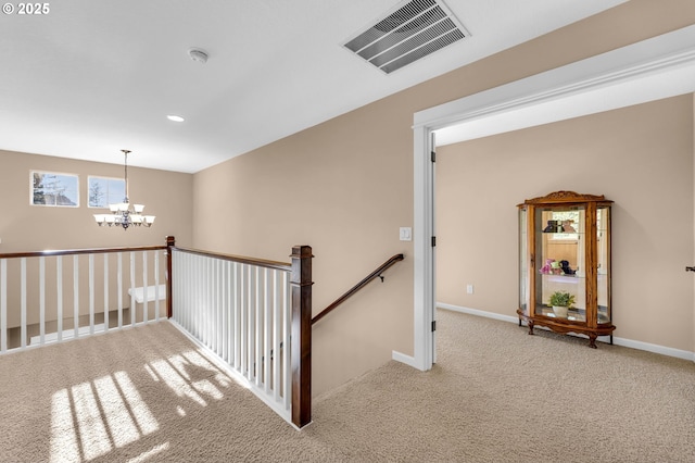 corridor featuring light colored carpet and a chandelier