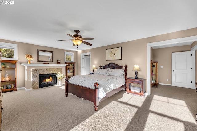 bedroom featuring ceiling fan, a fireplace, and carpet flooring