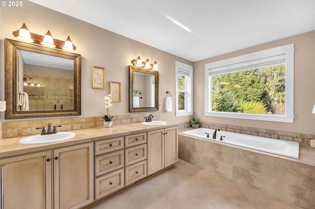 bathroom featuring vanity, tiled bath, and tile patterned flooring