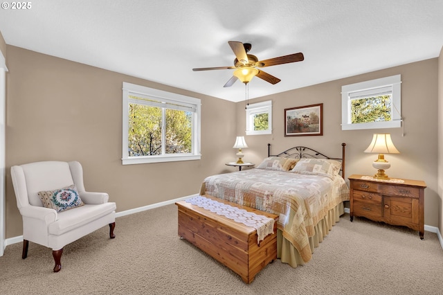 carpeted bedroom featuring multiple windows and ceiling fan