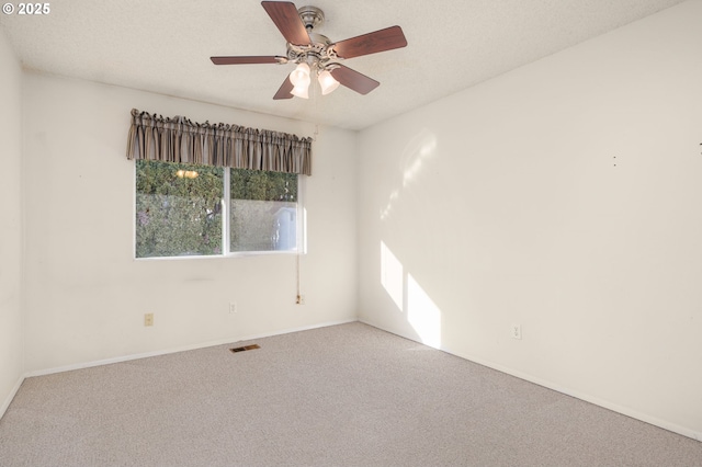 spare room featuring ceiling fan, carpet, and a textured ceiling