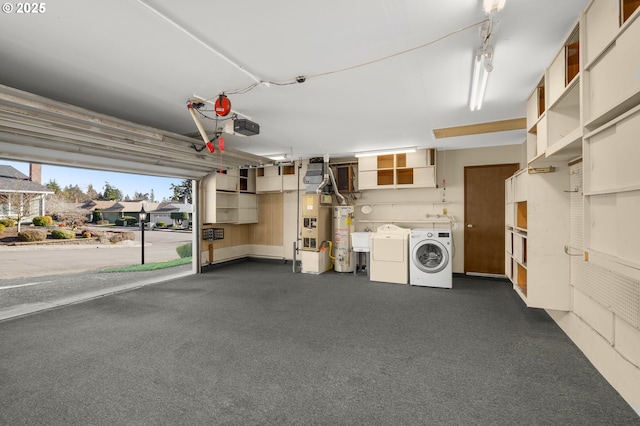 garage with water heater, a garage door opener, and independent washer and dryer