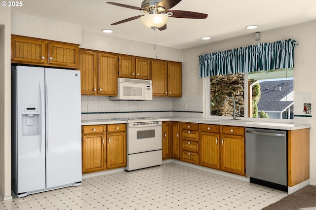 kitchen with tasteful backsplash, sink, white appliances, and ceiling fan