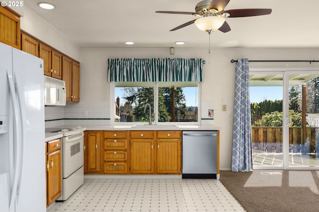 kitchen featuring sink, white appliances, a wealth of natural light, and backsplash