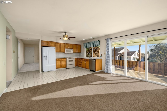 kitchen featuring ceiling fan, light colored carpet, and white appliances