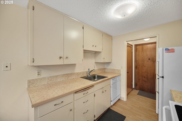 12841 SE Stark St Unit A19, Portland, OR 97233 - kitchen with a sink, white appliances, light wood-style flooring, a textured ceiling, and cream cabinets