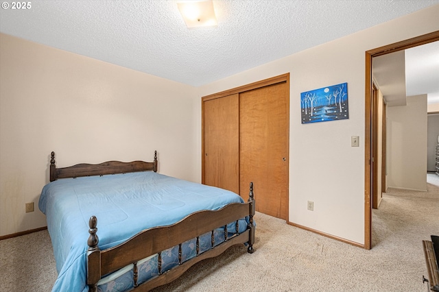 12841 SE Stark St Unit A19, Portland, OR 97233 - bedroom featuring light colored carpet, a closet, baseboards, and a textured ceiling
