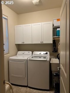 clothes washing area with cabinets and washing machine and clothes dryer