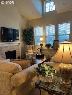 living room with a premium fireplace and a high ceiling