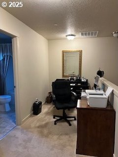 home office with light carpet and a textured ceiling