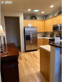 kitchen featuring appliances with stainless steel finishes, backsplash, and light hardwood / wood-style floors