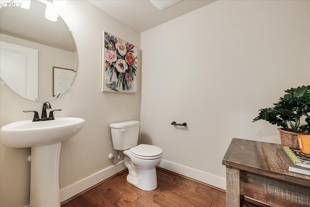 bathroom with sink, toilet, and hardwood / wood-style floors